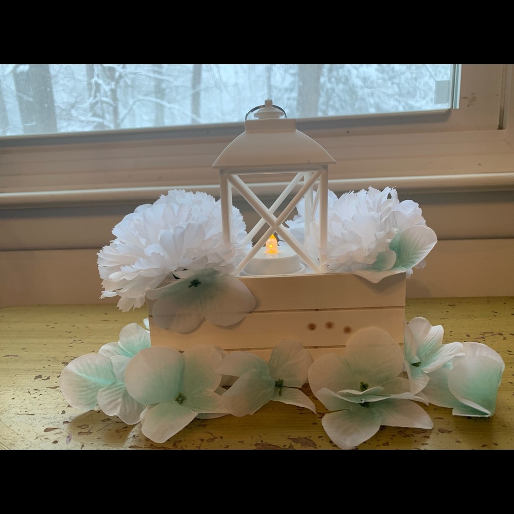 Crate and lantern centerpiece with light blue flowers on base and top